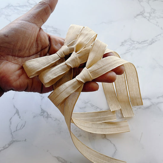 Hand holding a Sara Knot Long Tailed Hair Bow