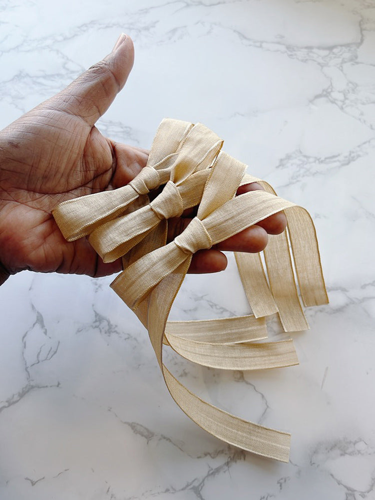 Hand holding a Sara Knot Long Tailed Hair Bow