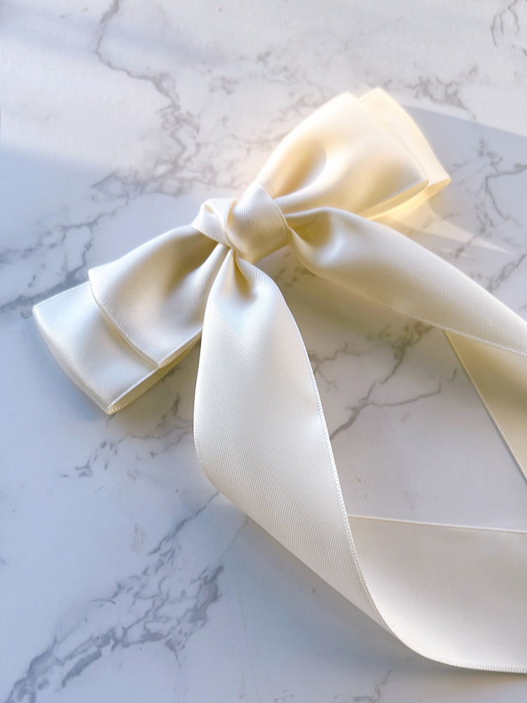 An ivory satin ribbon bow with long tails