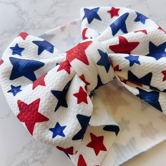 Baby headband with red, white, and blue star pattern on a marble surface
