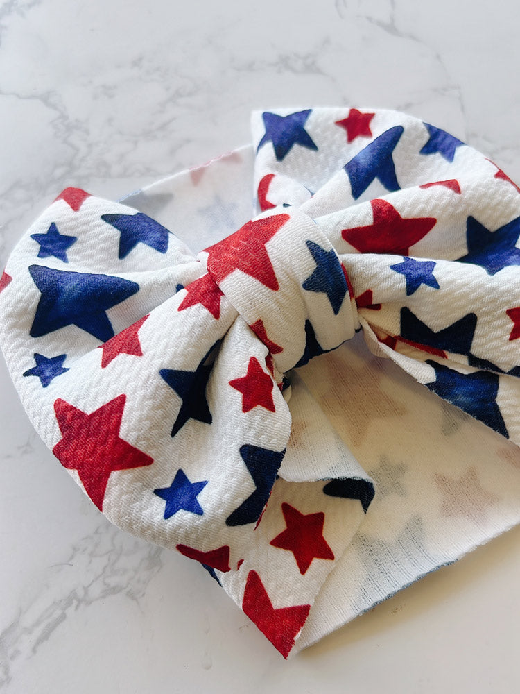 Baby headband with red, white, and blue star pattern on a marble surface